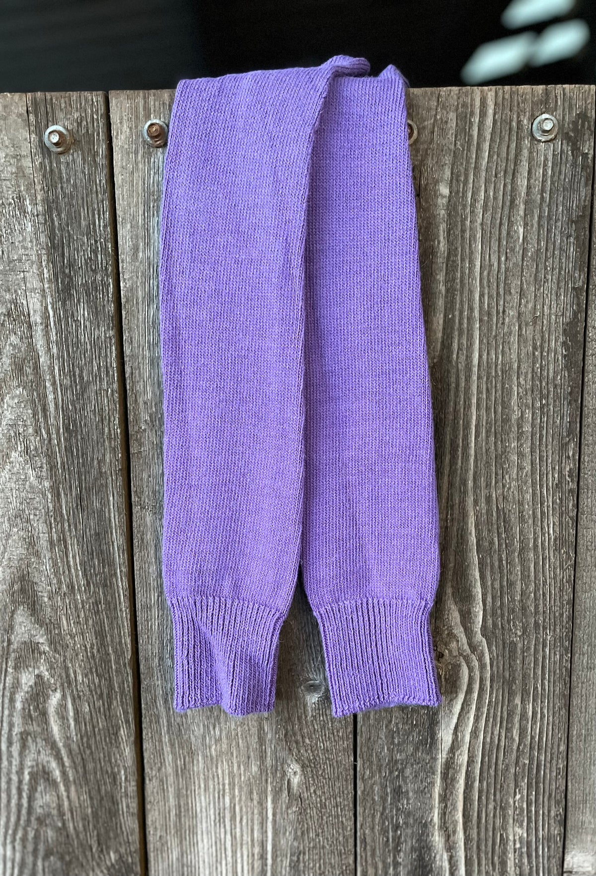 Purple long activity alpaca socks on a wooden surface