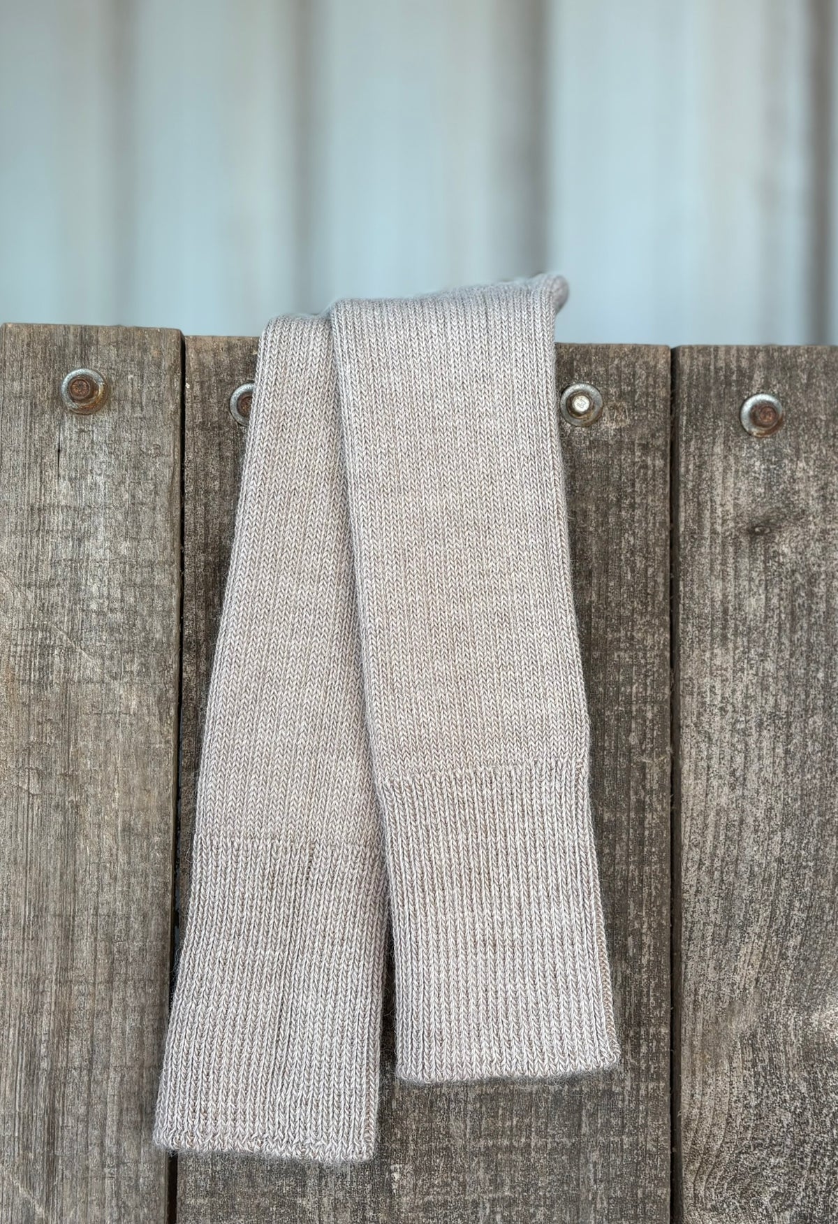 taupe three quarter socks hanging on wooden gate