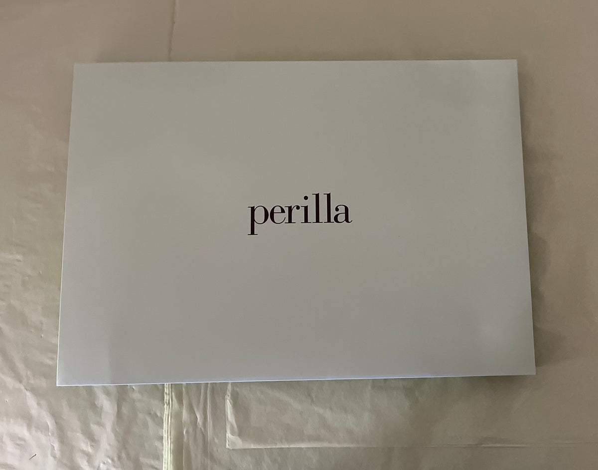 green gift envelope with 'perilla' branding on a beige surface