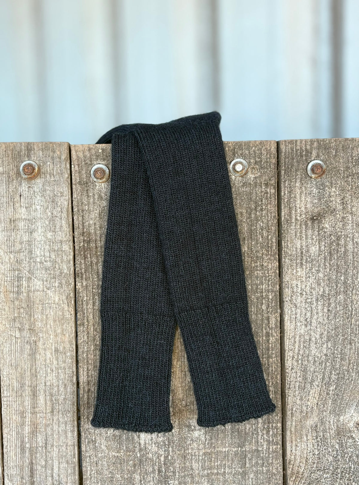 black three quarter alpaca socks hanging on wooden door