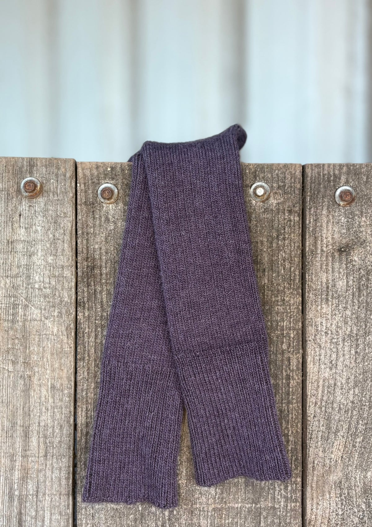 grape three quarter alpaca socks hanging over wooden door