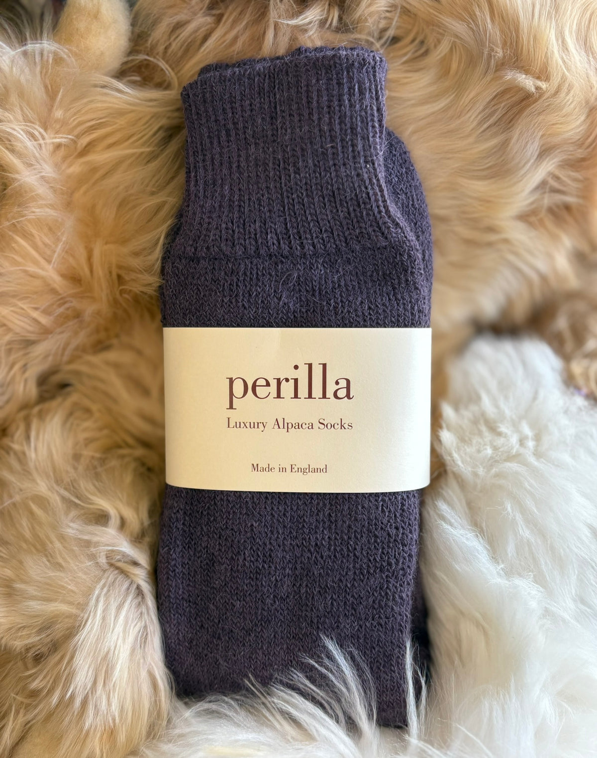 Grape alpaca walking sock with 'perilla' label on a fluffy beige surface