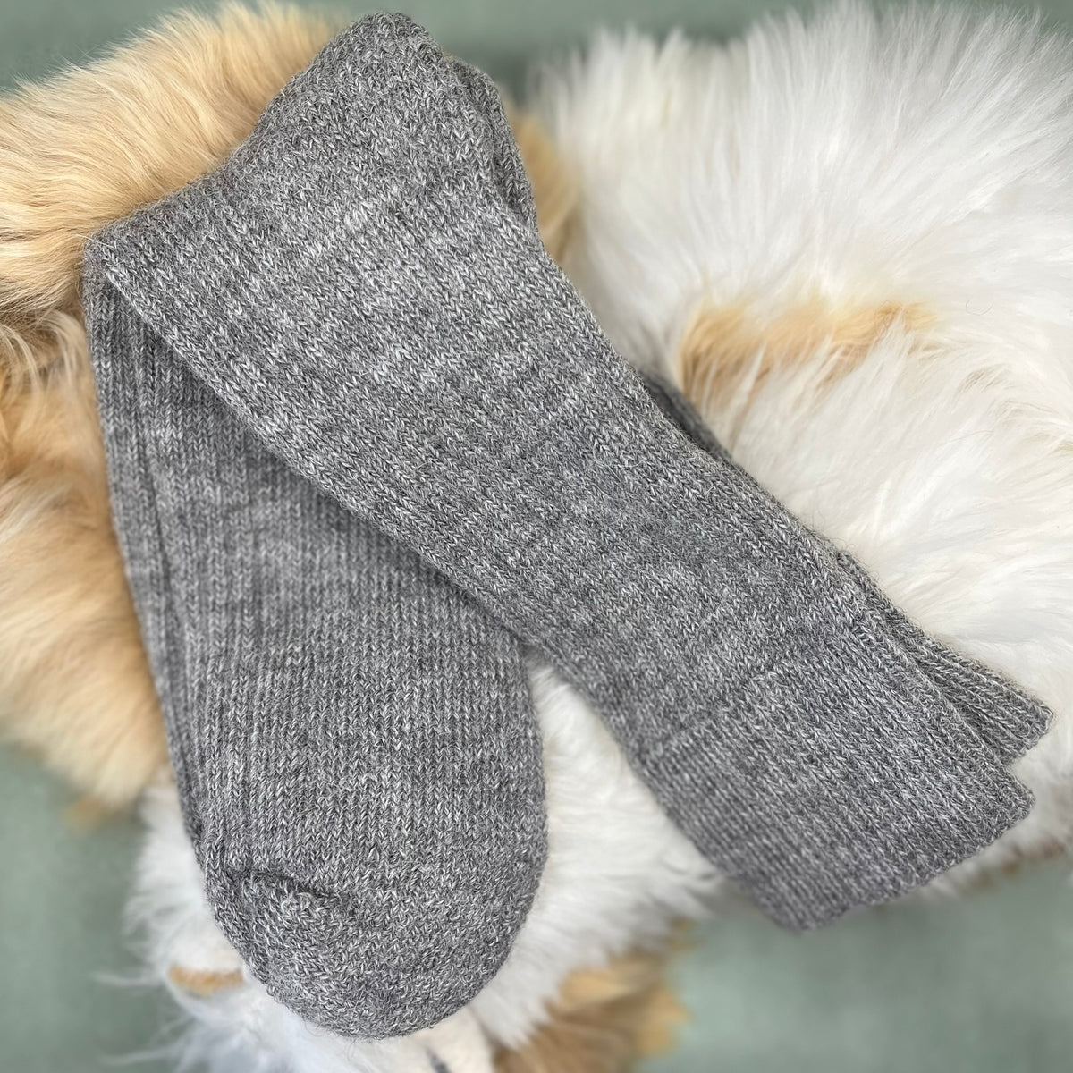 grey short ribbed alpaca socks on a fluffy white and brown surface