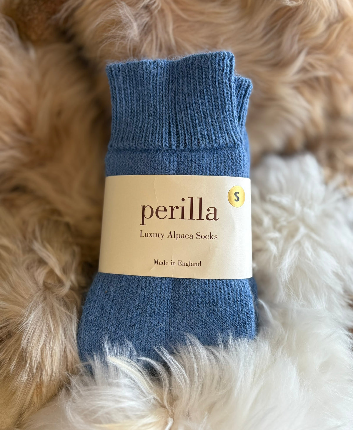 mid blue walking alpaca socks on fluffy background