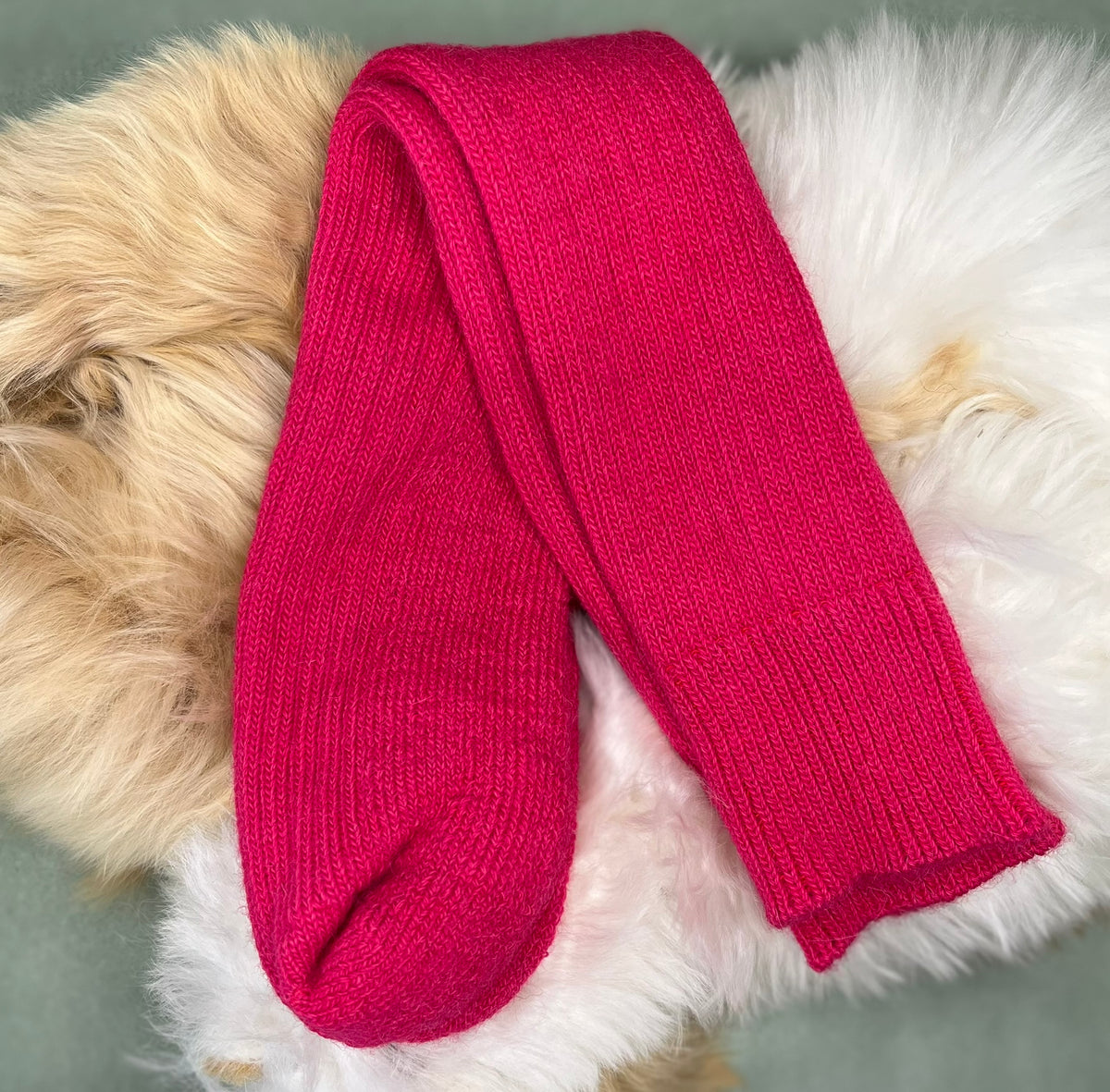 Raspberry alpaca short ribbed socks on a fluffy white and beige surface